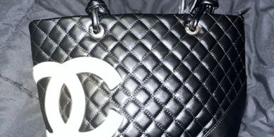 Black quilted handbag with prominent white Chanel logo.