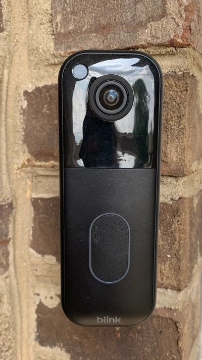 A Blink doorbell camera installed on a brick house