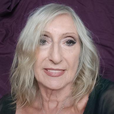 Smiling older woman with blonde hair and makeup.