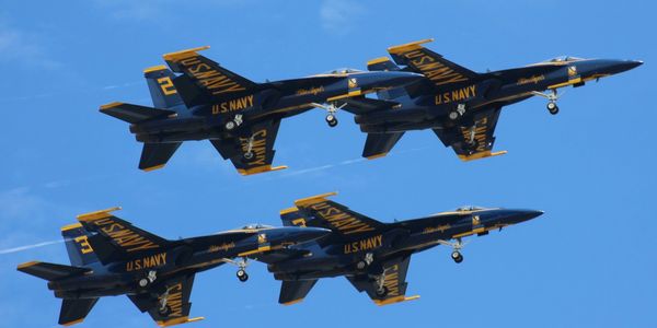 Four U.S. Navy fighter jets flying in formation.