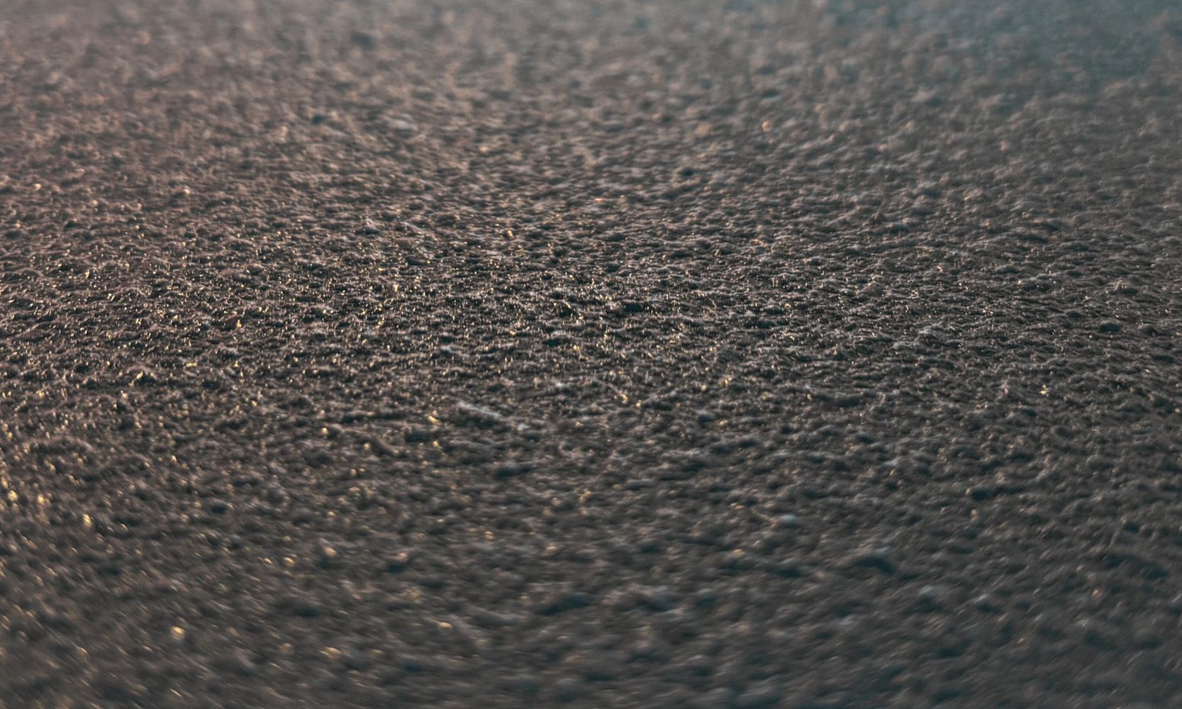 Close-up of a textured, dark surface with subtle lighting.