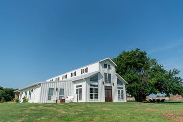 Elegant and rustic white barn venue with stained wood accents