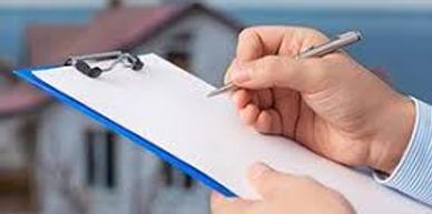 Person writing on a clipboard with a house in the background.
