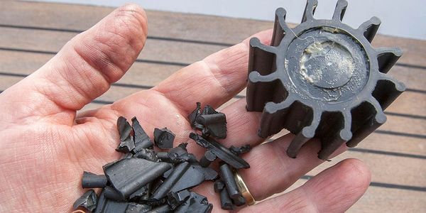 Hand holds broken and whole impeller parts.