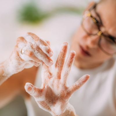 Woman with OCD examining her hands as she washes them