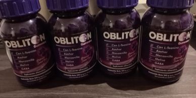 Four bottles of Obliton dietary supplement with purple caps.