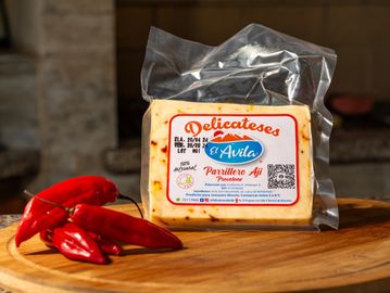 Queso con ají empaquetado junto a algunos ajíes rojos.