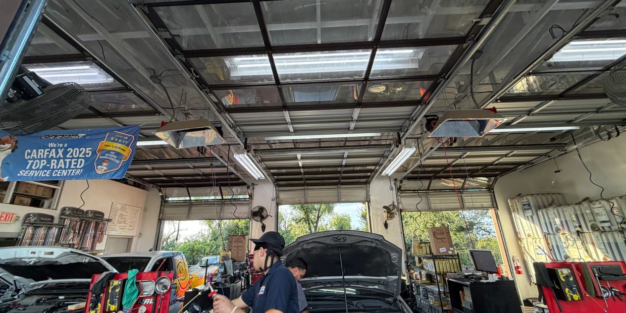 Auto repair shop with mechanics working on cars.