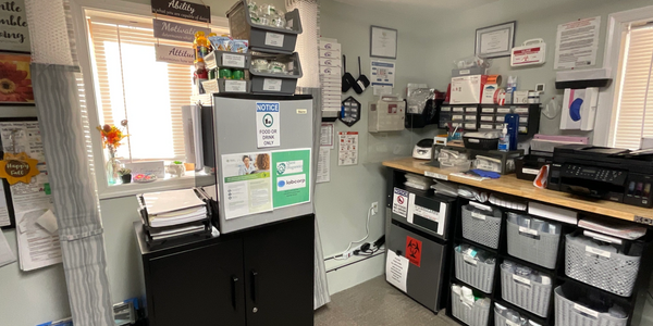 A small, organized office with two chairs and inspirational wall art.
