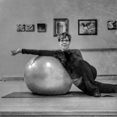 woman leaning against large stability ball