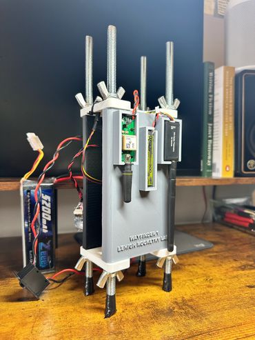 Custom-built electronic device on a wooden desk with wires and sensors.