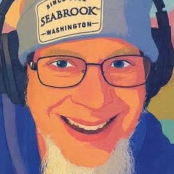 Smiling man with glasses and a long white beard wearing a hat and headphones.