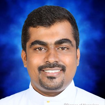Portrait of a smiling man with a neatly trimmed beard against a blue background.