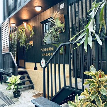 Cozy modern cafe entrance with greenery and warm lighting.