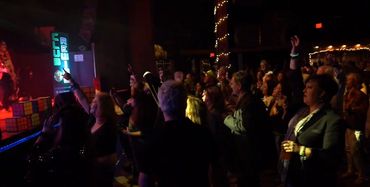 People enjoying a live music performance in a dimly lit venue.