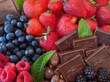 Dessert platter on a board with a choice of fruits, chocolates, cakes and nuts for events.