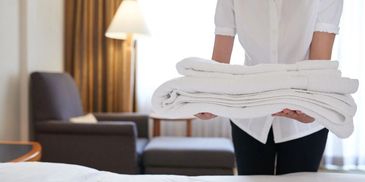 Person placing the towels on a bed