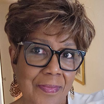 Close-up of a woman wearing large glasses and stylish earrings.