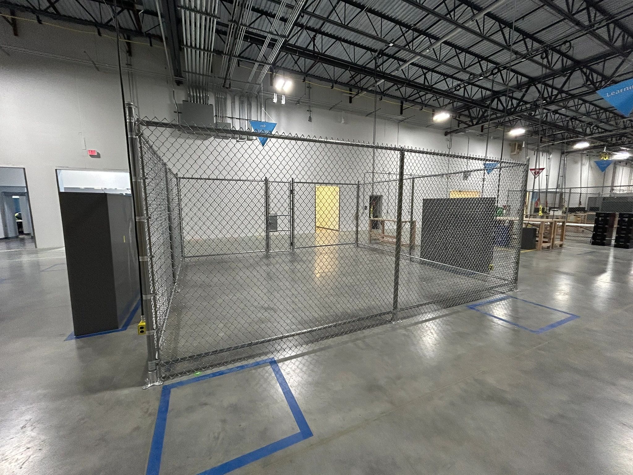 Interior warehouse safety cage and chain-link partition installed by Vier Eck Fence
