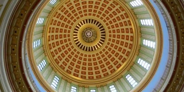 View of an ornate circular dome ceiling with windows.