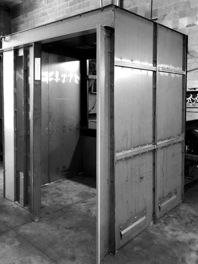 A metal and wooden structure in a workshop or industrial setting.