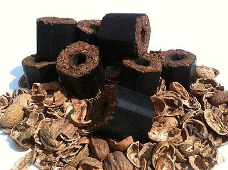 Hexagonal walnut shell briquettes resting on walnut shells