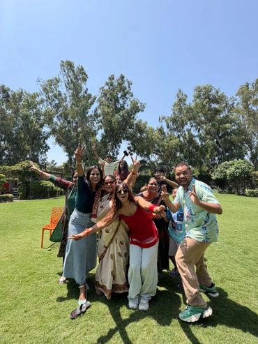 Group of friends joyfully posing outdoors on a sunny day.