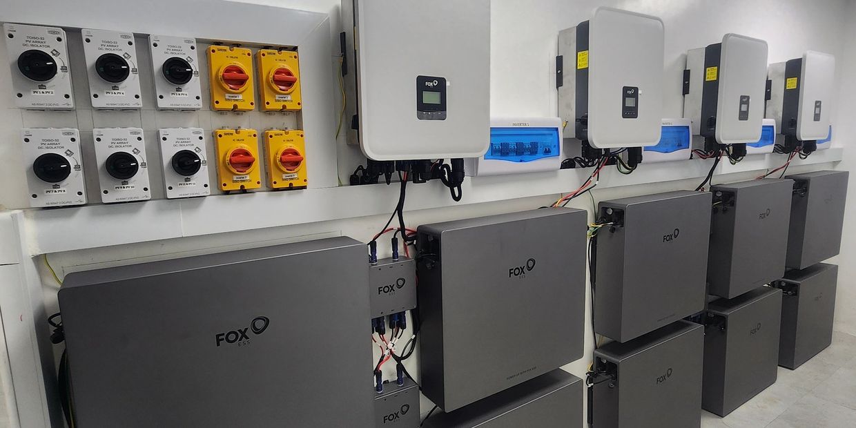 A neat installation of FOX branded battery storage and inverter units on a wall.