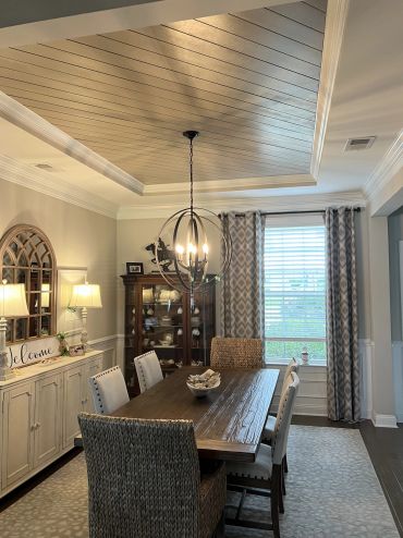 Cozy dining room with wooden table and elegant lighting.