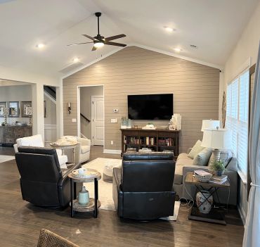 Modern living room with leather recliners and wall-mounted TV.