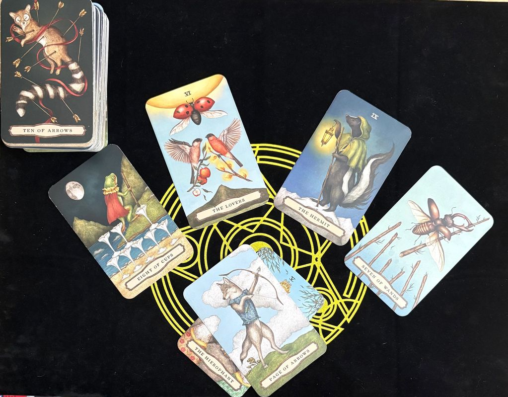Tarot cards with animal illustrations on a black and yellow mat.