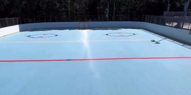 Empty outdoor roller hockey rink under sunlight with clear markings.