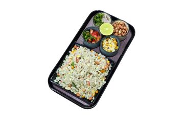 Indian poha served with peanuts, lemon, and chopped vegetables on a black tray.