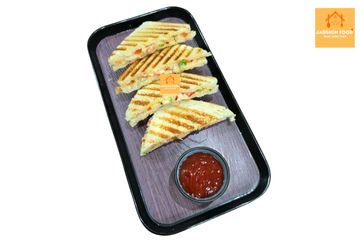 Grilled vegetable sandwiches with ketchup on a black tray.