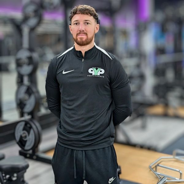 Man in black athletic wear standing in a gym.
