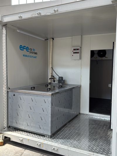 Mobile ice plant unit inside a metal container with stainless steel flooring.