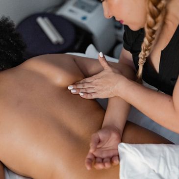 A therapist giving a back massage to a client lying face down.