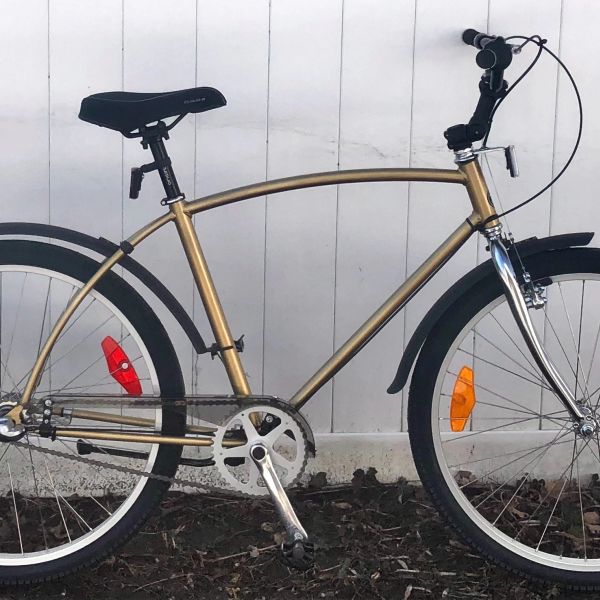 Metallic gold bicycle with black seat and tires.