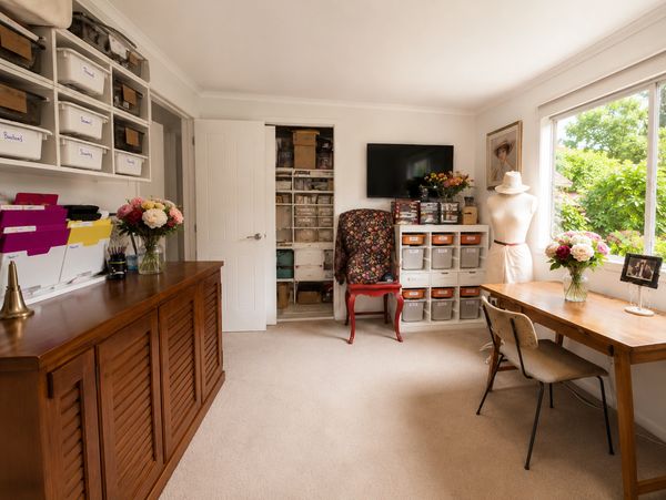 Bateman Original Designs sewing and millinery studio, with organised materials, floral trims, dress form and dedicated workspaces for creating handmade hats, accessories and custom apparel.