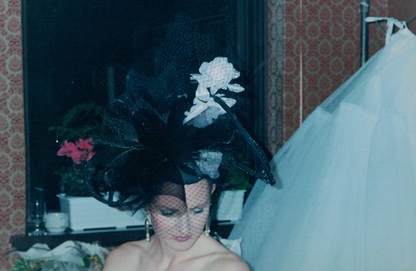 Black racewear hat with three pink roses, crinoline spirals and Russian netting.