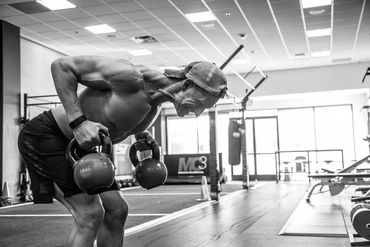 Man lifting kettlebells in gym