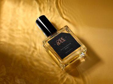 Cade Black perfume on gold reflective background.