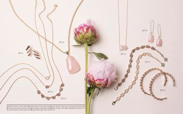 Gold jewelry and rose quartz necklaces styled with flowers.