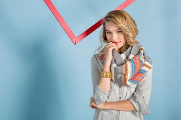 Woman with scarf against blue backdrop – bold fashion editorial