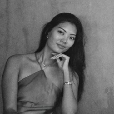 Black and white portrait of a woman with long hair, smiling gently.