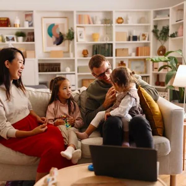 A happy family enjoying time together on a couch in a cozy living room.