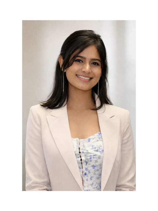 Smiling woman in a light blazer and floral top.