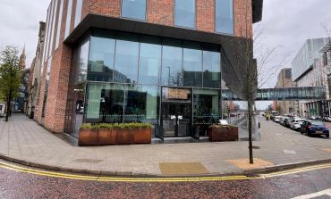 Modern corner building with large glass windows and entrance.
