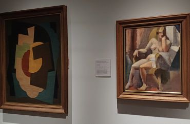 Two abstract paintings displayed on a gallery wall.