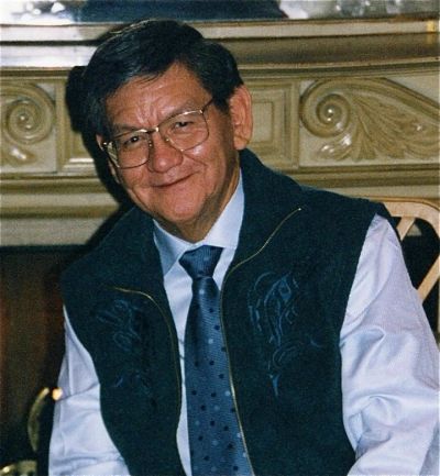 Smiling man wearing glasses and a tie.
